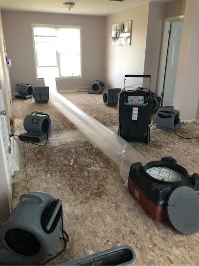 Air movers and ducting drying a stripped subfloor in Greeley