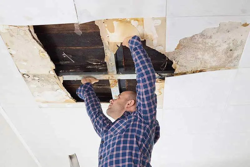 Water-damaged ceiling opened to the joists after a leak in Greeley