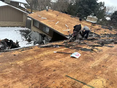 Storm-damaged roof opened to the decking on a Greeley house