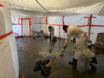 Worker in a protective suit cleaning inside containment during sewage cleanup in Greeley
