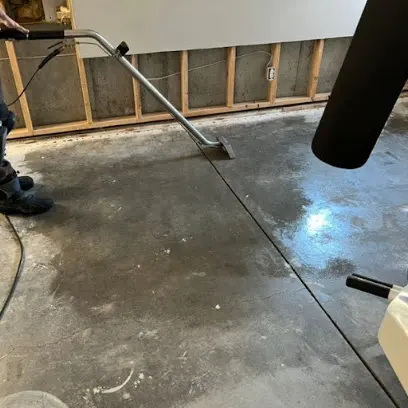 Extraction wand on a wet concrete floor after a flood cut in a Greeley basement